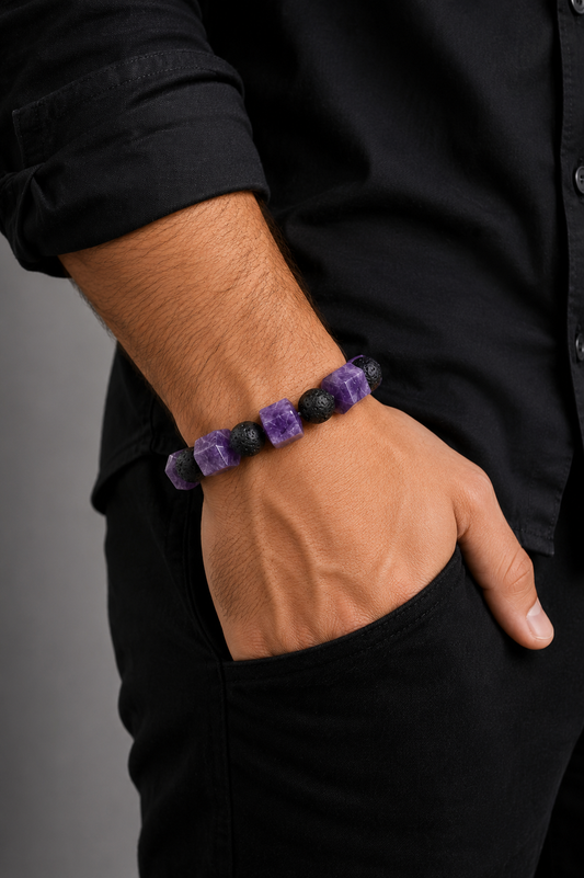 Person wearing a purple beaded bracelet on a plain background