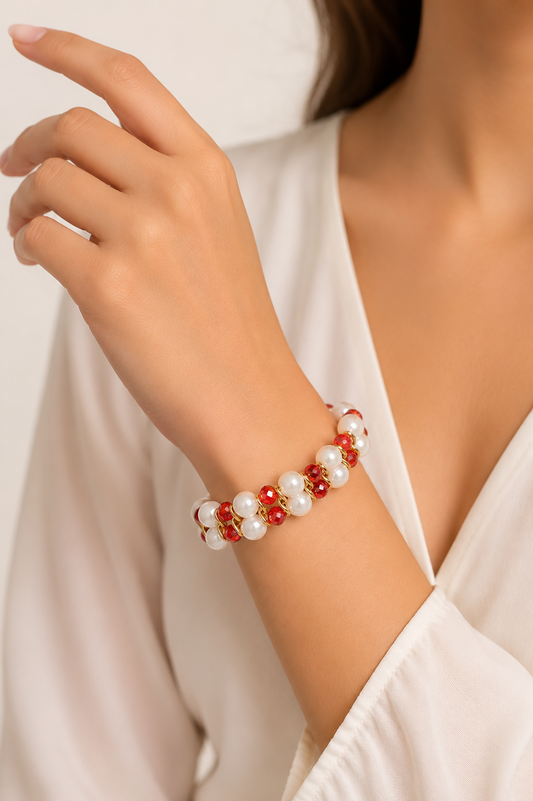 Close-up of a wrist wearing a red and white beaded bracelet against a neutral background