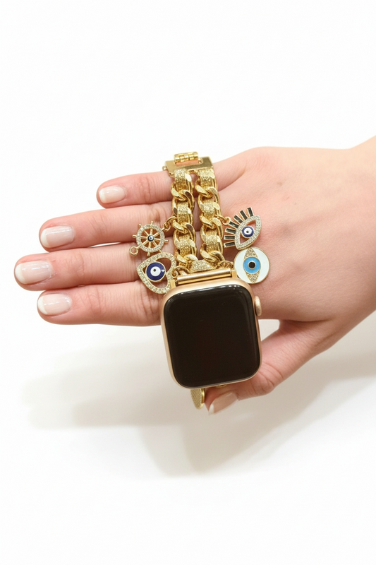 Hand wearing a gold watch band with decorative charms on a white background