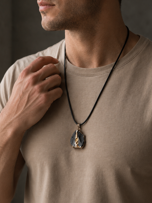 Man wearing a necklace with a pendant against a neutral background