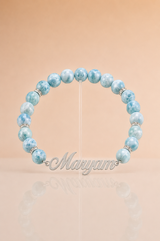 Beaded bracelet with blue beads and silver accents on a beige background, featuring the brand 'Maryam'.
