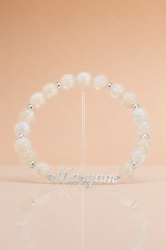 Pearl bracelet with silver beads on a stand against a beige background