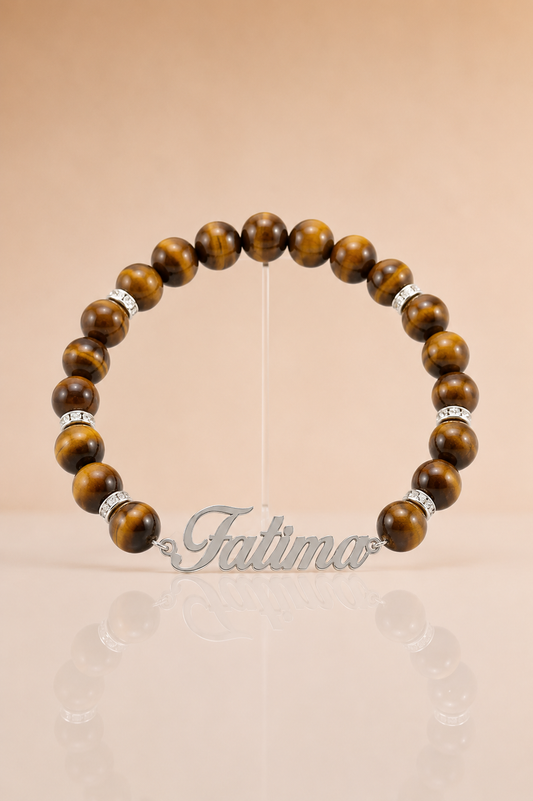 Wooden beaded bracelet with silver accents on a beige background, branded 'Tatima'.