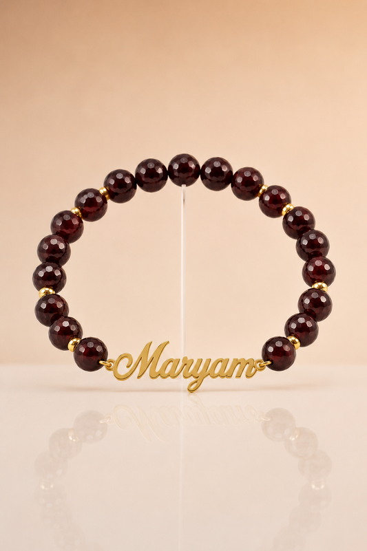 Beaded bracelet with 'Maryam' charm on a beige background