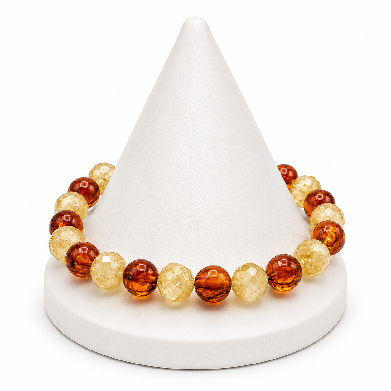 Beaded bracelet with amber and gold stones on a white cone-shaped stand