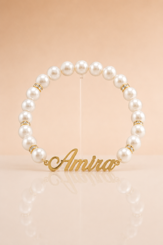 Pearl bracelet with gold name charm 'Amira' on a beige background