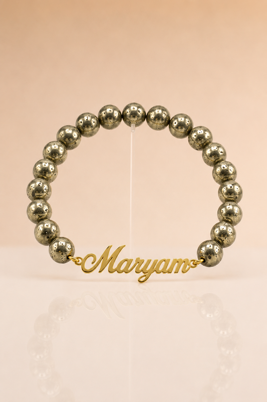 Beaded bracelet with a gold nameplate on a beige background