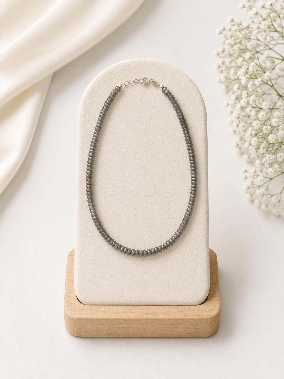 Necklace on a white stand with a light background
