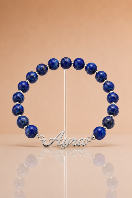 Blue beaded bracelet with a silver nameplate on a beige background