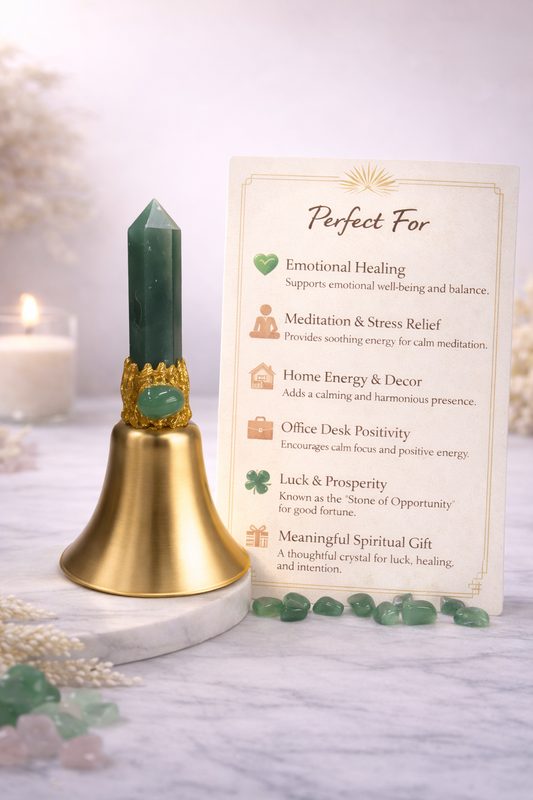 Decorative bell with green crystal on a white surface, accompanied by a card describing its uses.