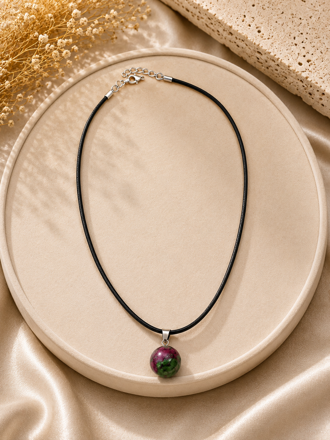 Necklace with a pendant on a beige plate