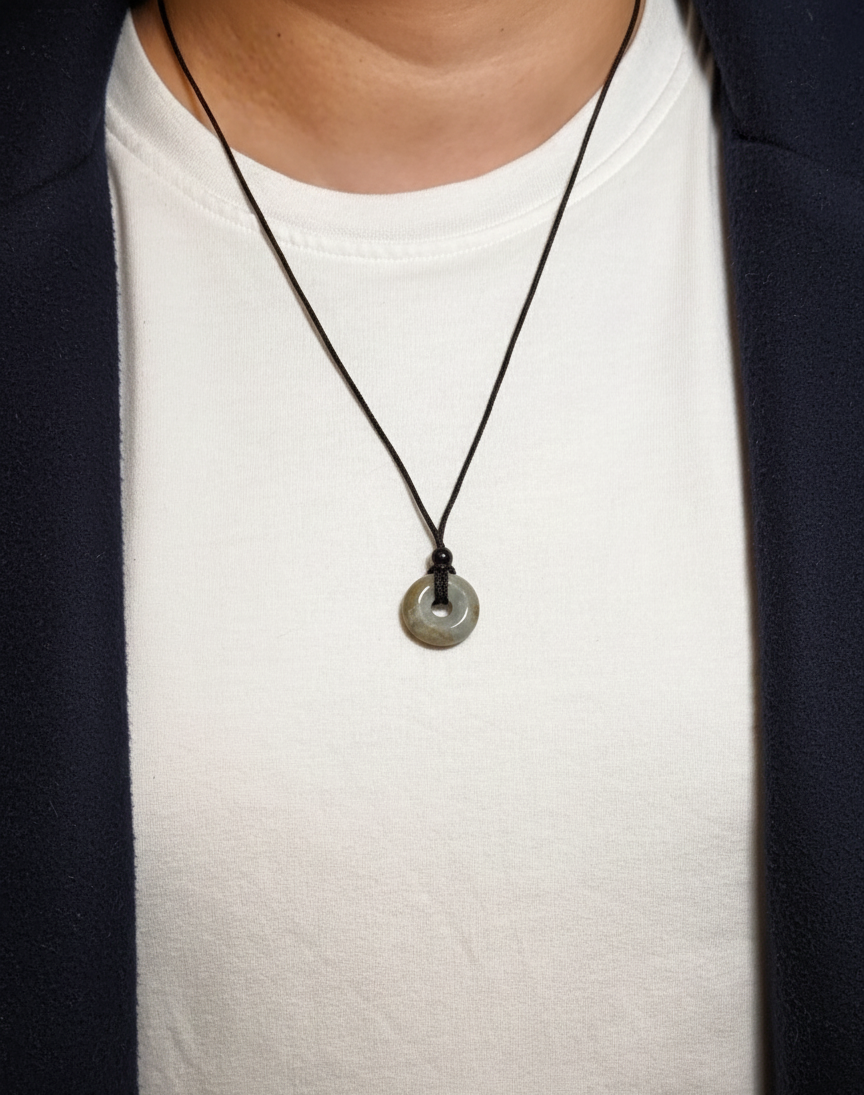 Necklace with a pendant worn by a person on a white shirt