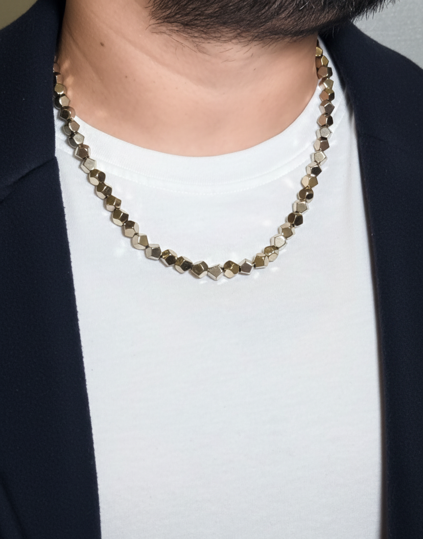 Necklace with beaded design worn by a person against a neutral background