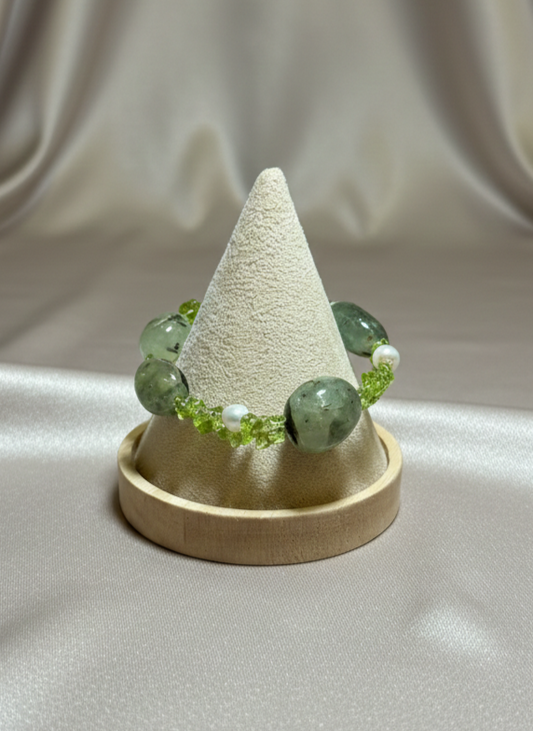 Green beaded bracelet on a cone-shaped display with a beige background