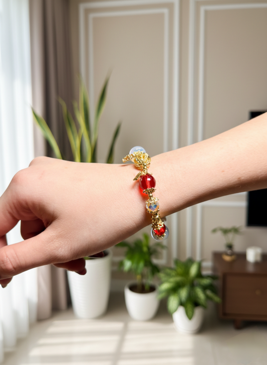 Person wearing a decorative bracelet with red beads in a home setting