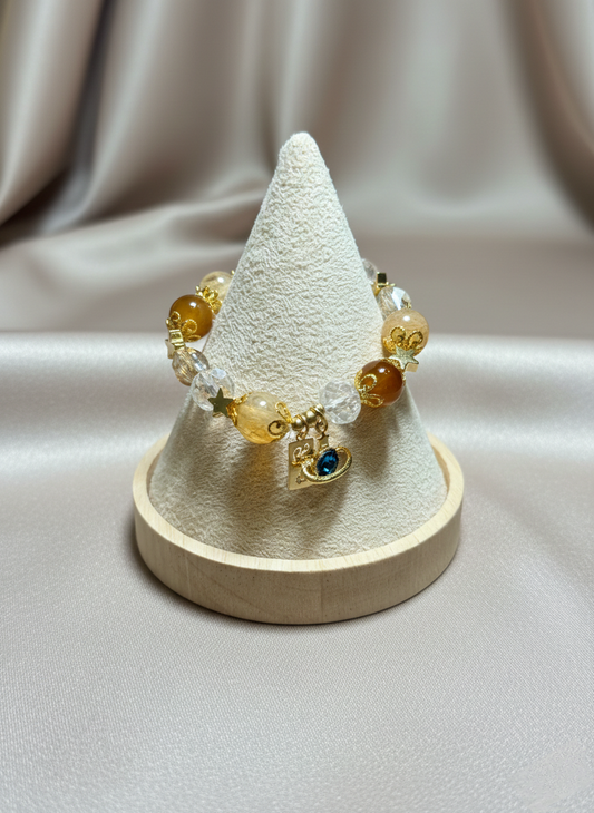 Bracelet with yellow and clear beads on a cone-shaped display stand against a beige background
