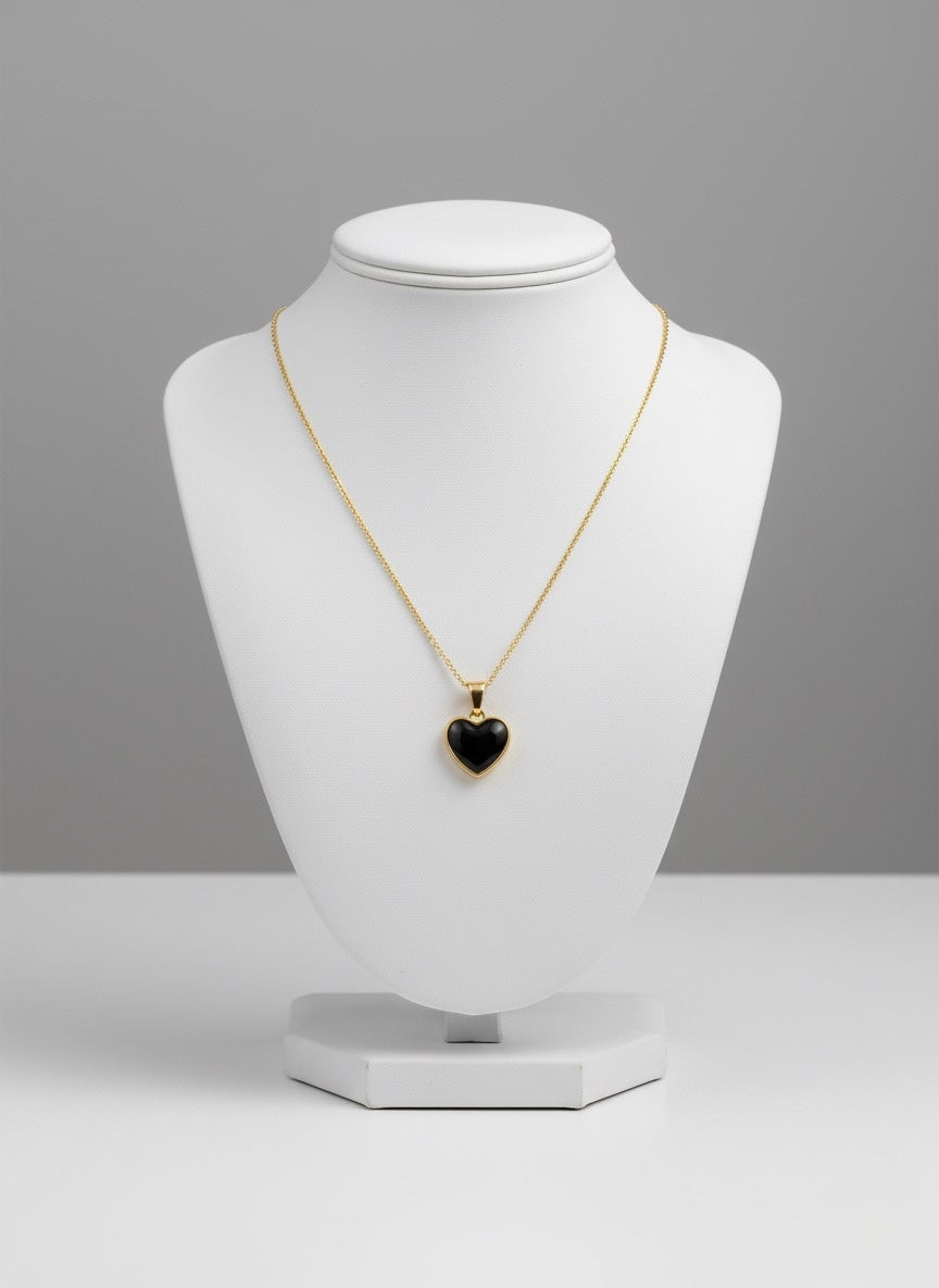 black obsidian crystal heart pendant on gold chain on stand