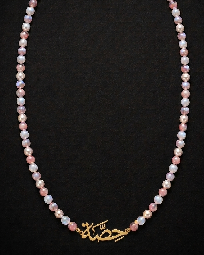 Pearl necklace with gold clasp on a black background