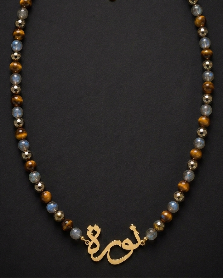 Necklace with beads and gold charm on a dark background