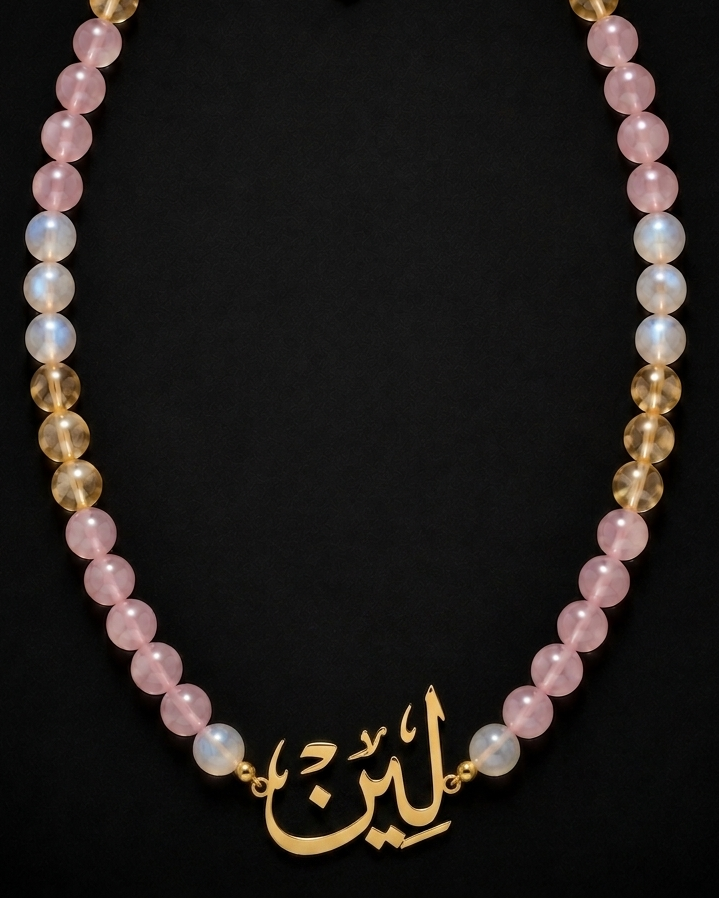 Necklace with pink and gold beads on a black background