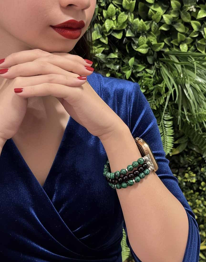 Woman wearing a blue top with greenery in the background