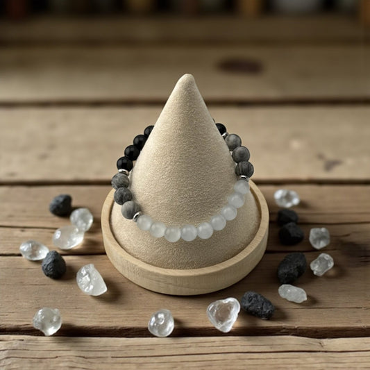 Beaded bracelet on a cone-shaped wooden display with crystals on a wooden surface