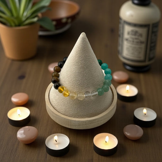 Beaded bracelet on a cone-shaped display with candles and a plant in the background