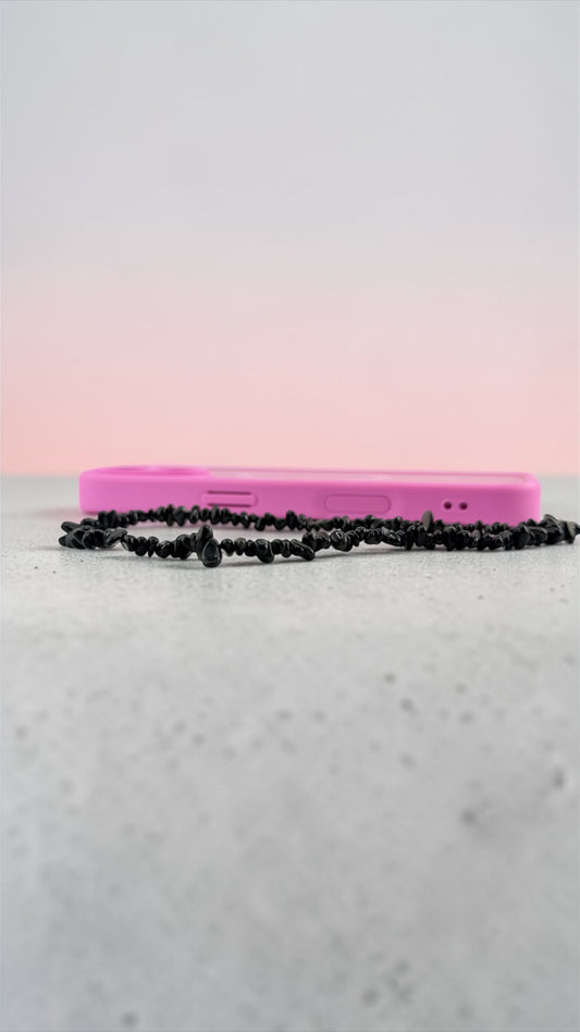 Pink phone case with a black chain on a light gray surface