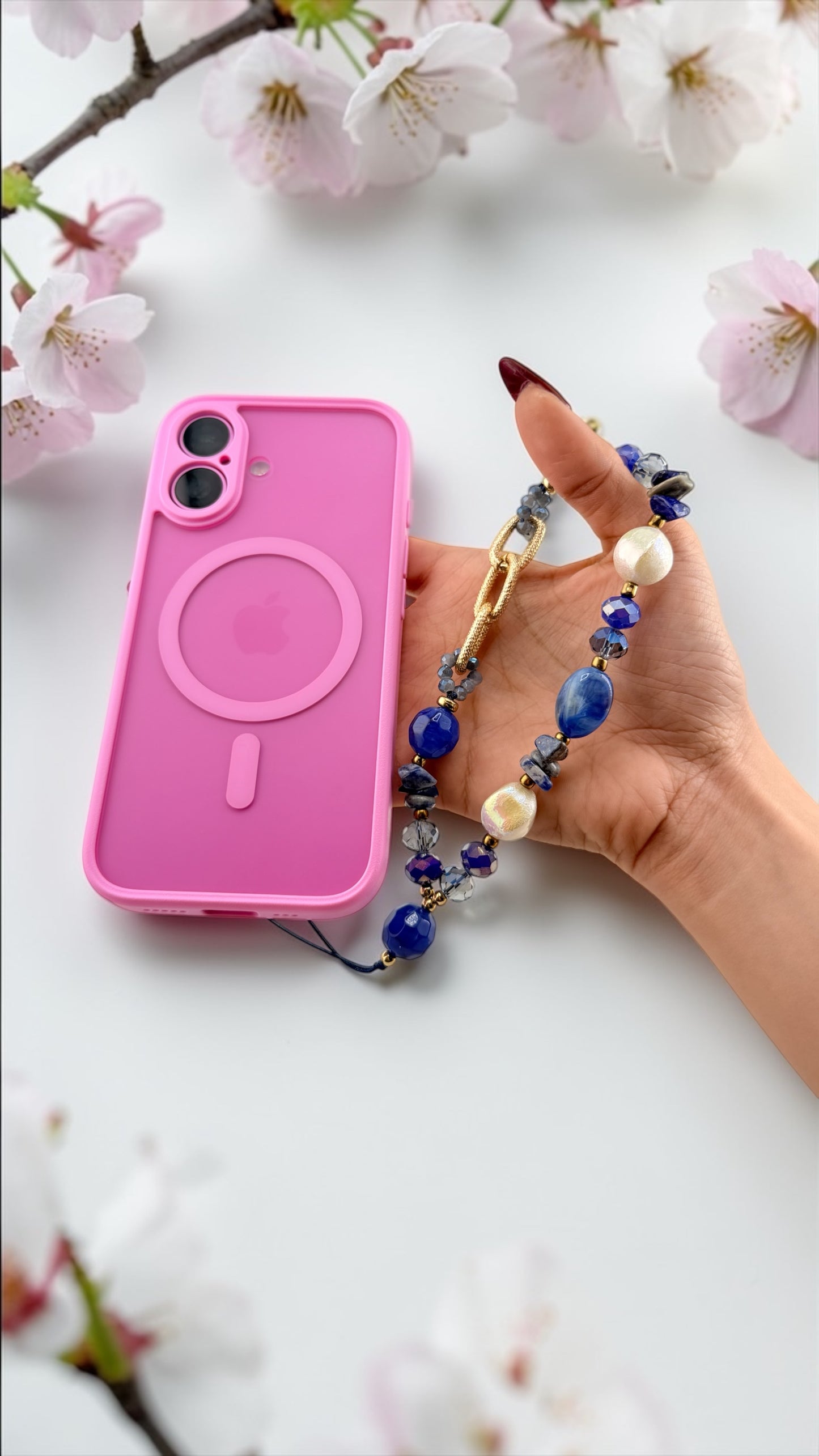 Hand holding a pink phone case with a floral background