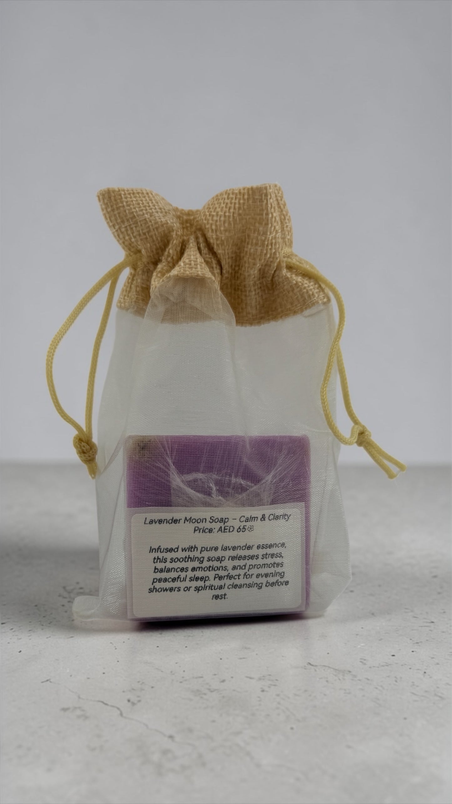 Lavender moon soap in a drawstring bag with a label on a light gray background