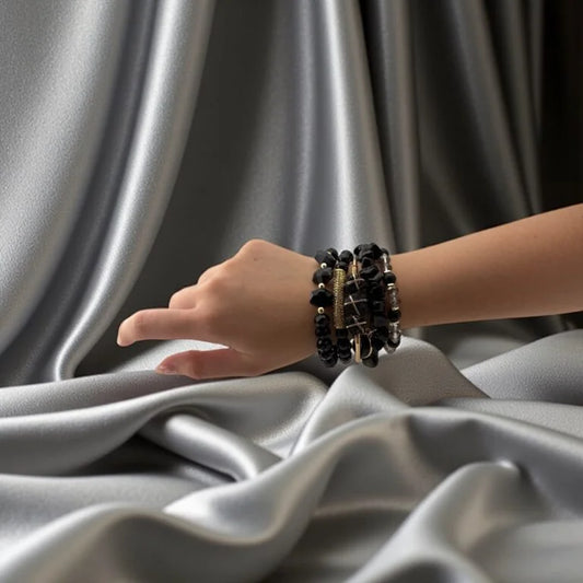 Hand wearing a bracelet on a gray fabric background
