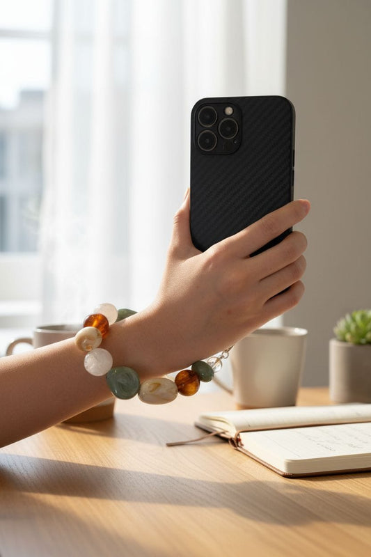 hand holding phone with crystal keychain hanging from case