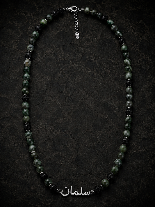 Necklace with black and green beads on a dark background