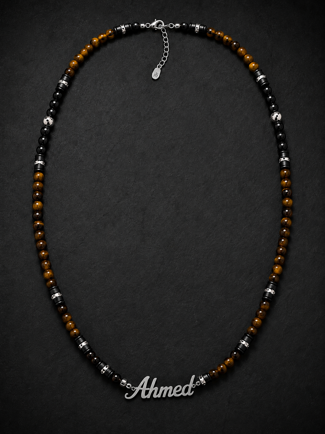 Necklace with beads and a nameplate on a dark background