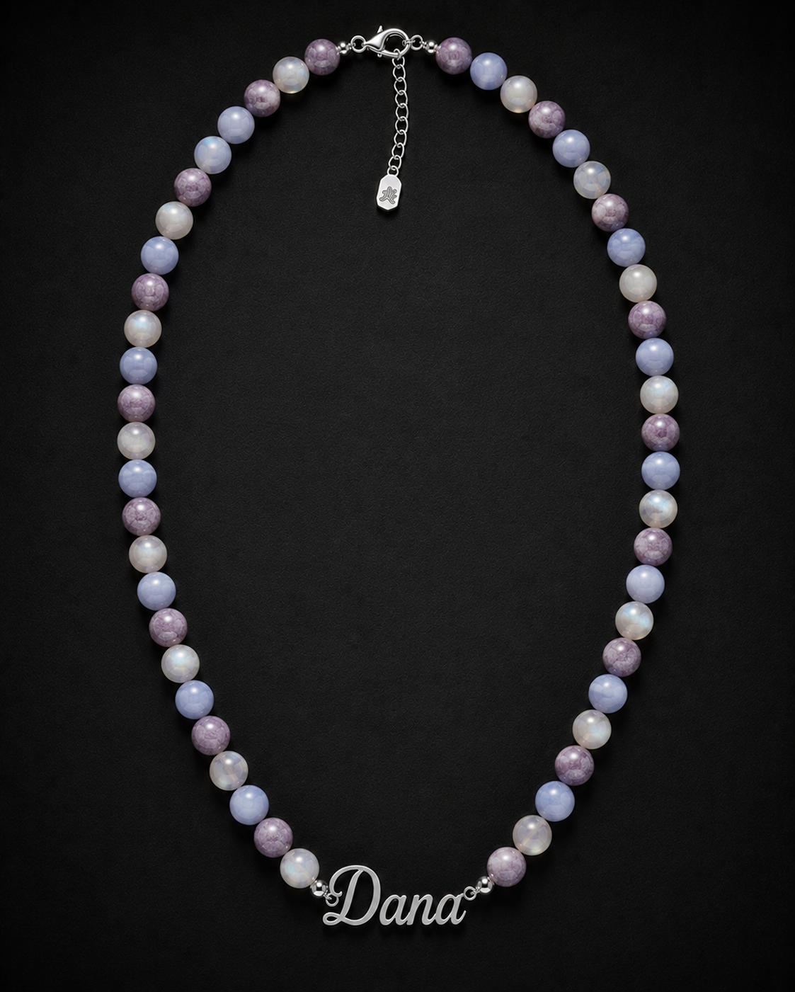 Necklace with multicolored beads and 'Dana' clasp on a black background