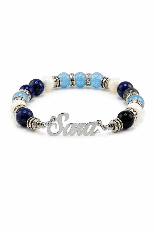 Bracelet with blue and black beads and a silver nameplate on a white background