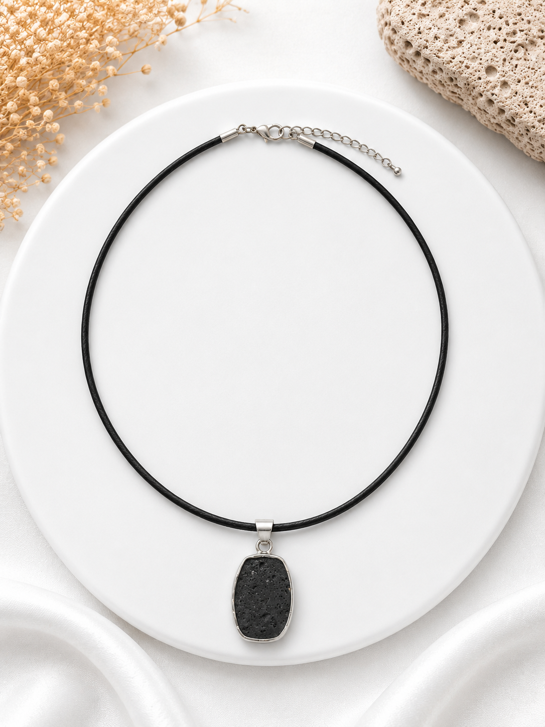 Necklace with a black pendant on a white plate