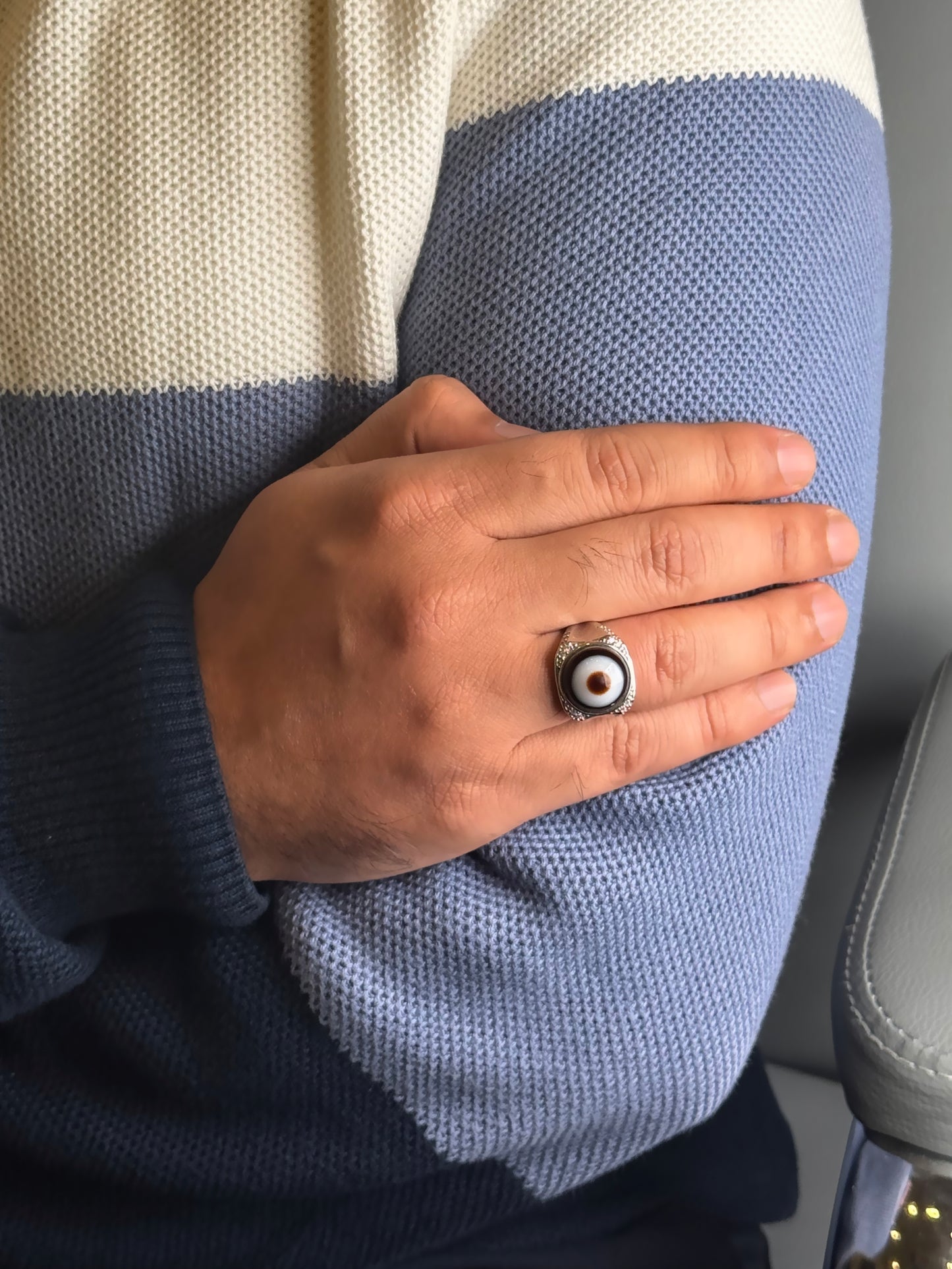 Close up of banded Agate evil eye style ring on a man’s hand