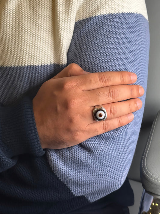 Close up of banded Agate evil eye style ring on a man’s hand