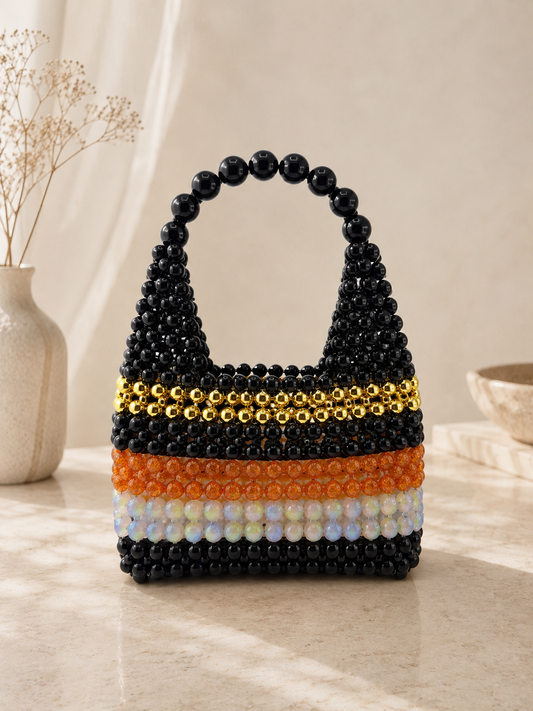 Beaded handbag with black, orange, and white stripes on a neutral background