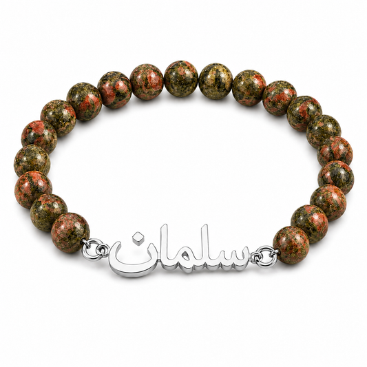 Bracelet with unakite beads and a silver charm on a white background