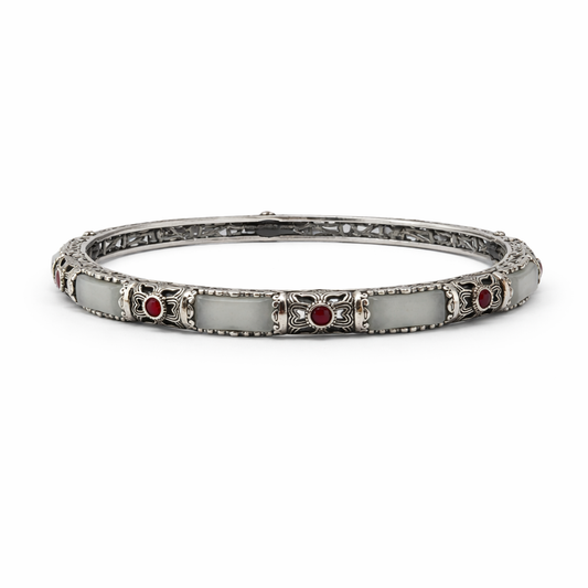 Silver bracelet with red stones on a white background