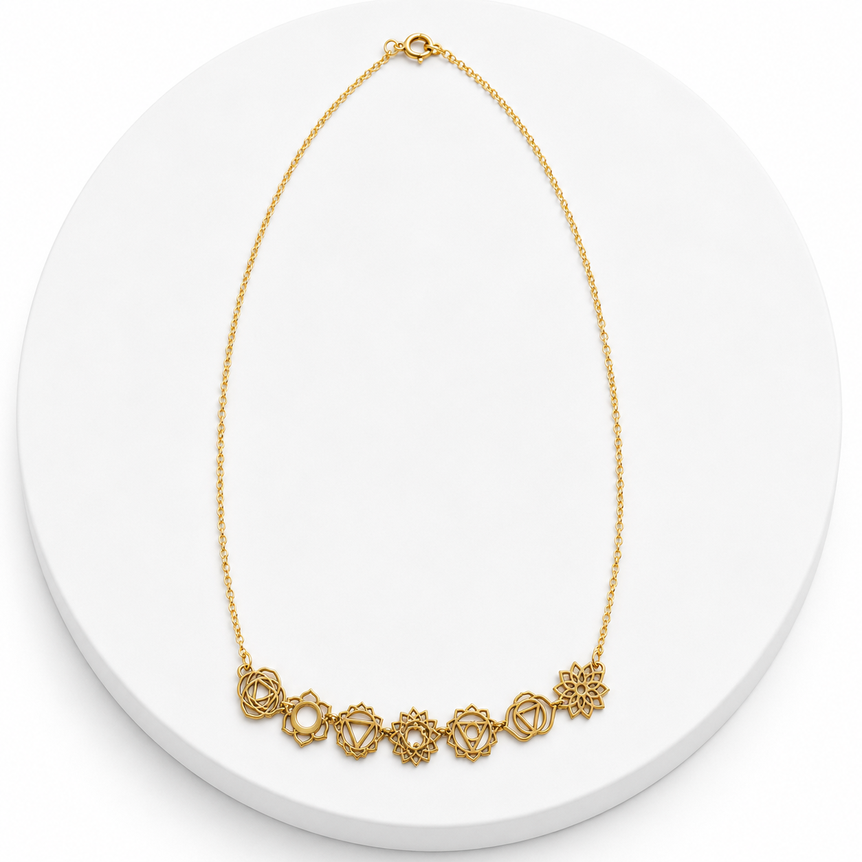 Gold necklace on a white circular stand