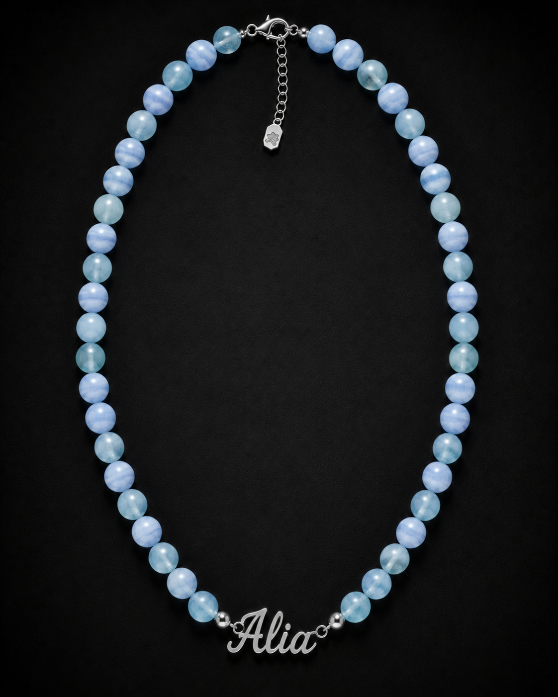 Blue beaded necklace with 'Alia' charm on a black background
