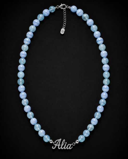 Blue beaded necklace with 'Alia' charm on a black background