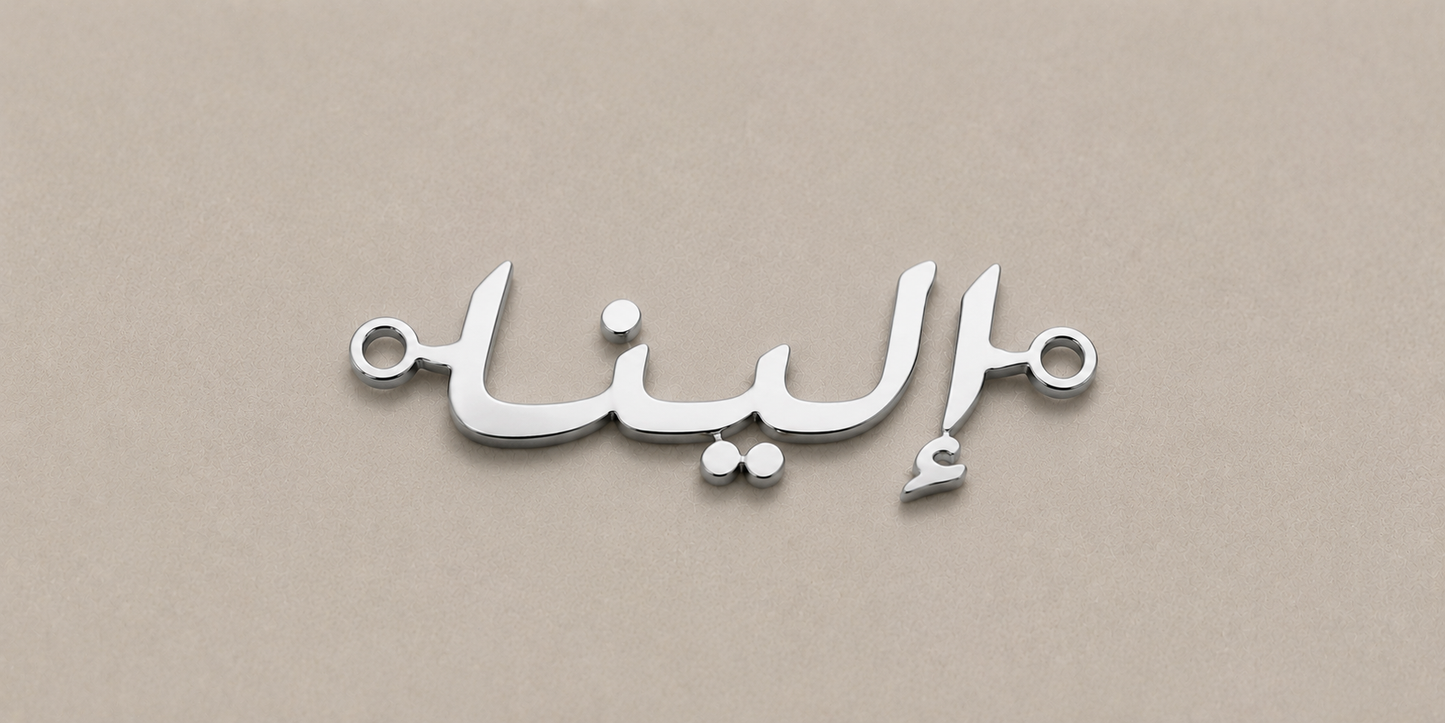 Silver nameplate with Arabic text on a beige background