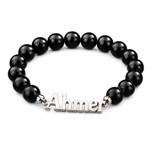 Black beaded bracelet with a silver 'Ahmer' charm on a white background