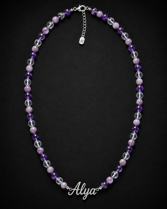 Necklace with purple and clear beads and a name charm on a black background