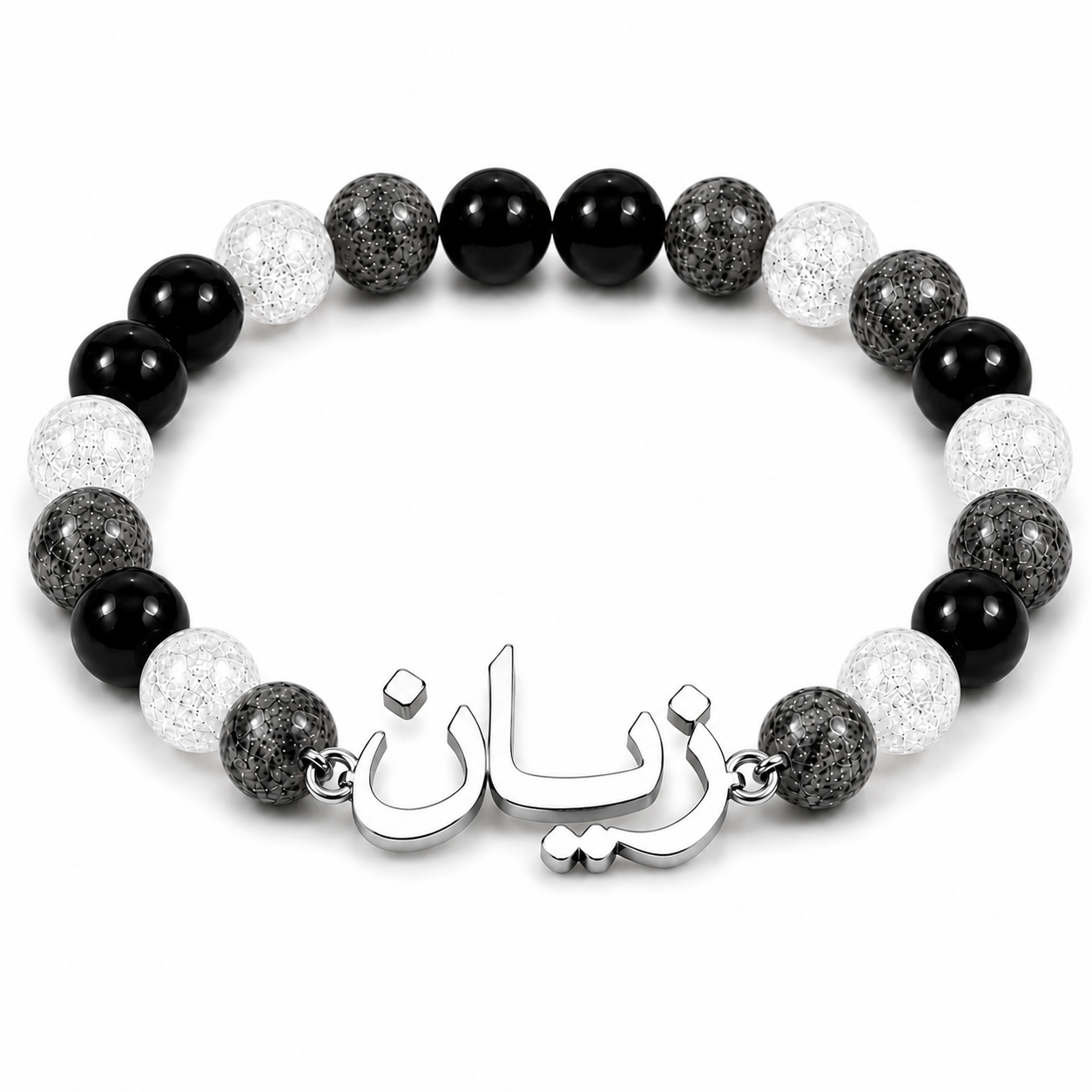 Beaded bracelet with black, white, and gray stones and a silver charm on a white background