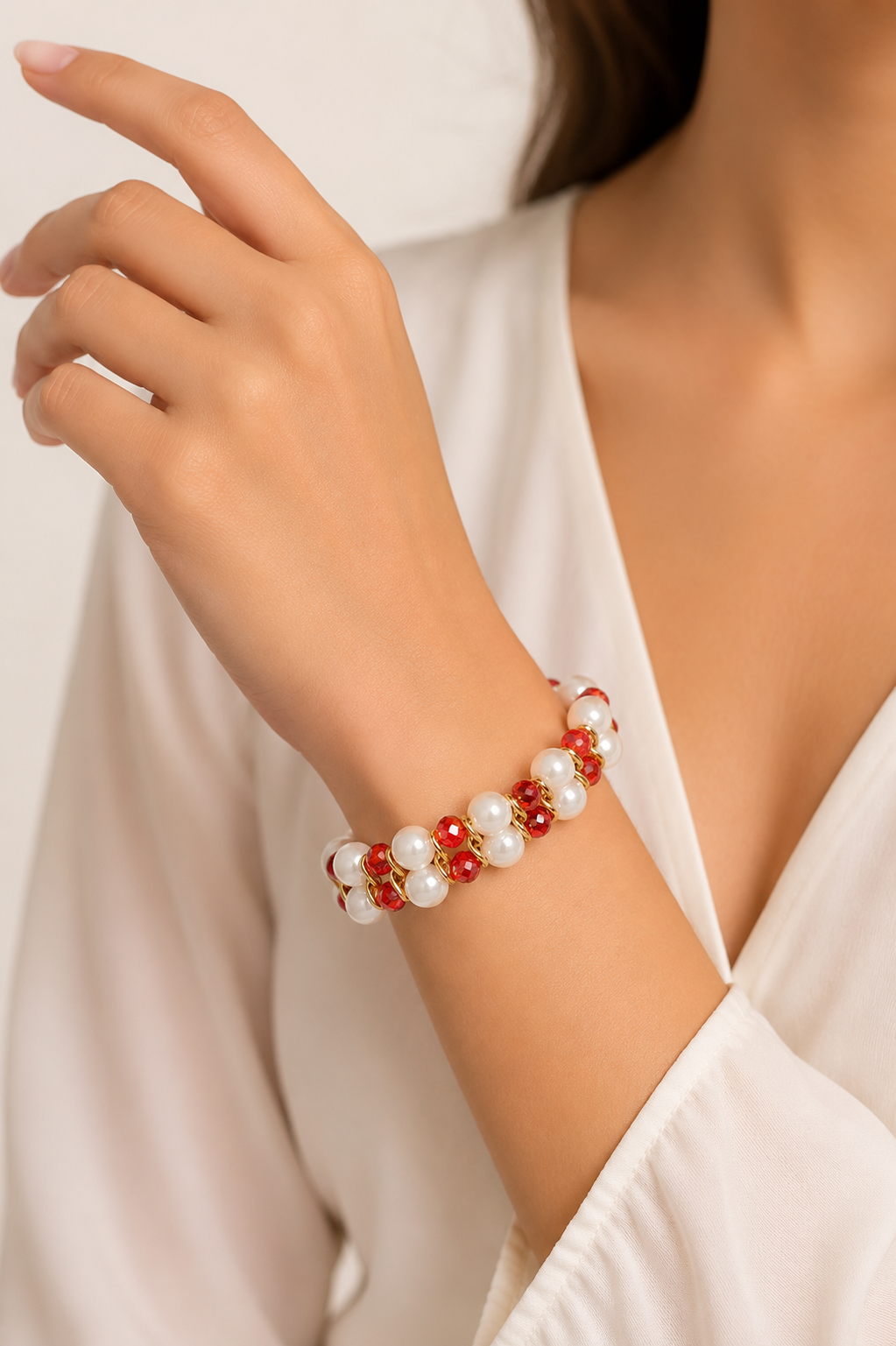Close-up of a wrist wearing a red and white beaded bracelet against a neutral background